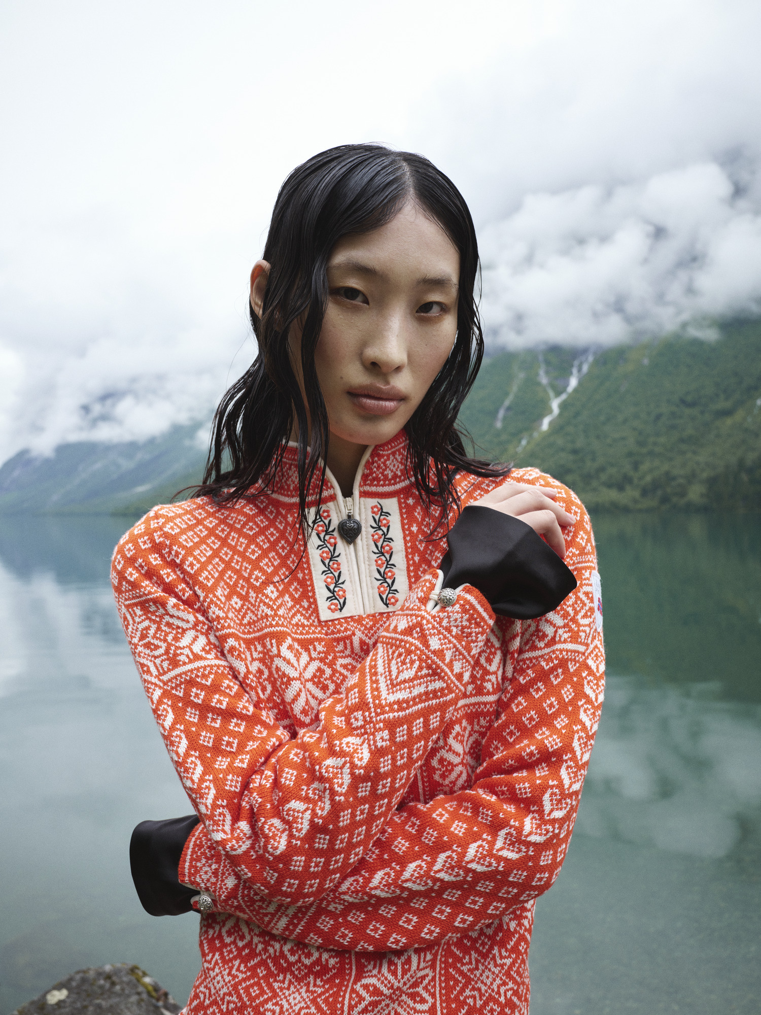 Female mode wearing Dale of Norway wool sweater standing by the Norwegian fjords